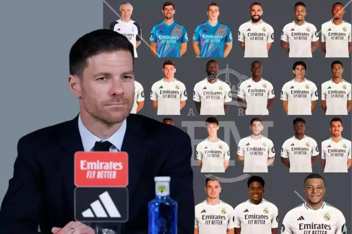 A man in a suit at a press conference, with photos of Real Madrid players in their white uniforms in the background.