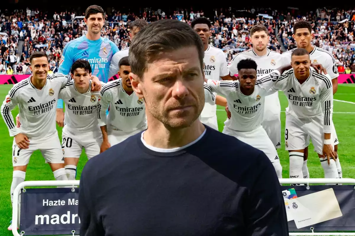 A group of players in white uniforms posing on the field, with a man in the foreground.