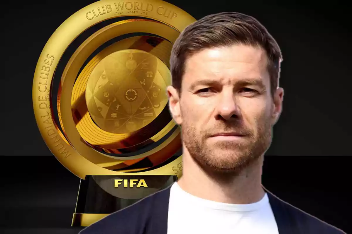 A man in front of a golden FIFA Club World Cup trophy.