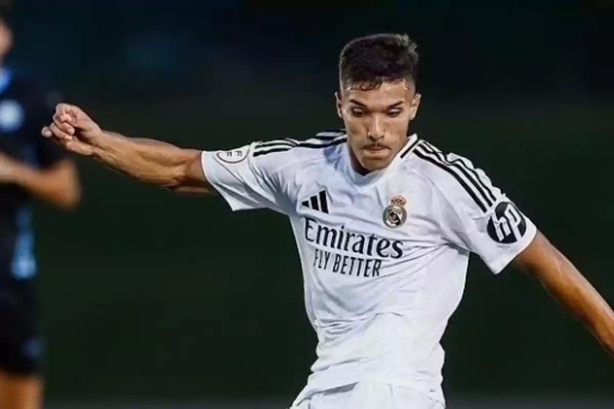Jugador de fútbol con uniforme blanco en acción durante un partido. Jugador de fútbol con uniforme blanco en acción durante un partido.