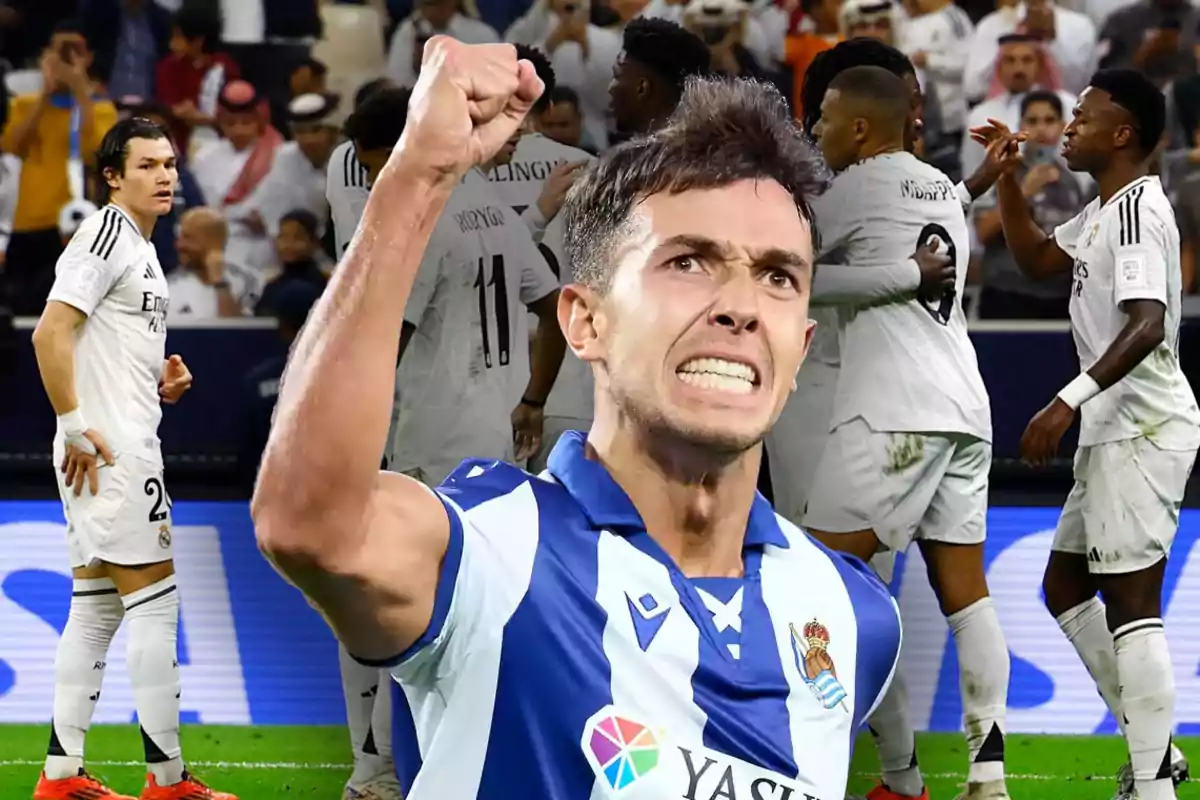 Un jugador de fútbol con uniforme azul y blanco celebra con el puño en alto mientras otros jugadores con uniforme blanco se agrupan al fondo.